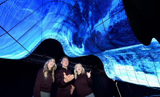 LG전자가 7일(현지시간)부터 미국 라스베이거스에서 열리는 CES 2020 전시회에 참가한다. LG전자는 부스 입구에 올레드 플렉서블 사이니지 200여 장을 이어 붙여 만든 '새로운 물결(New Wave)'이라는 이름의 조형물을 연출하고 관람객들의 이목을 집중시킨다. LG전자 모델들이 LG전자 전시관 입구에 마련된 올레드 조형물을 소개하고 있다. <LG전자 제공>